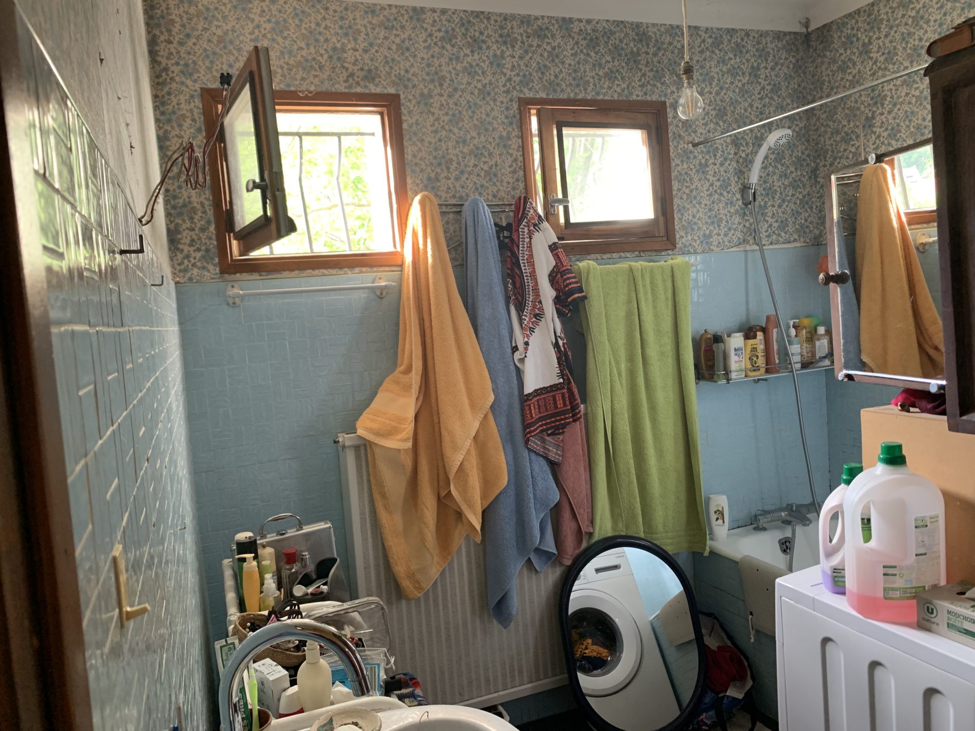 La salle de bain avant : lave-linge dangereux à cet emplacement et baignoire non adaptée pour une dame de 97 ans.