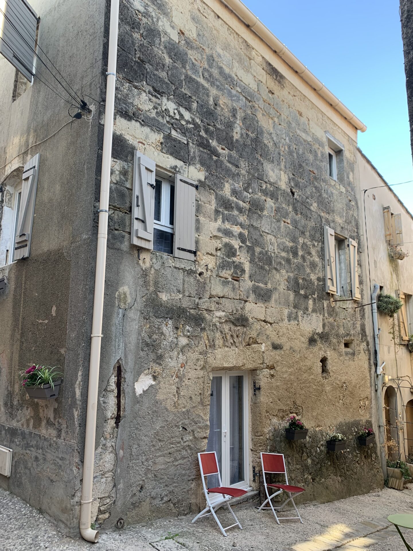 Façade en pierre d'une maison d'angle dans un village du cœur d'Hérault